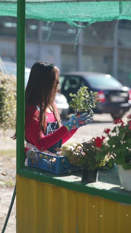 young woman selling flowers and produce at outdoor market