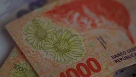 primer plano de billetes argentinos de diferentes denominaciones en cámara lenta, girando de izquierda a derecha
