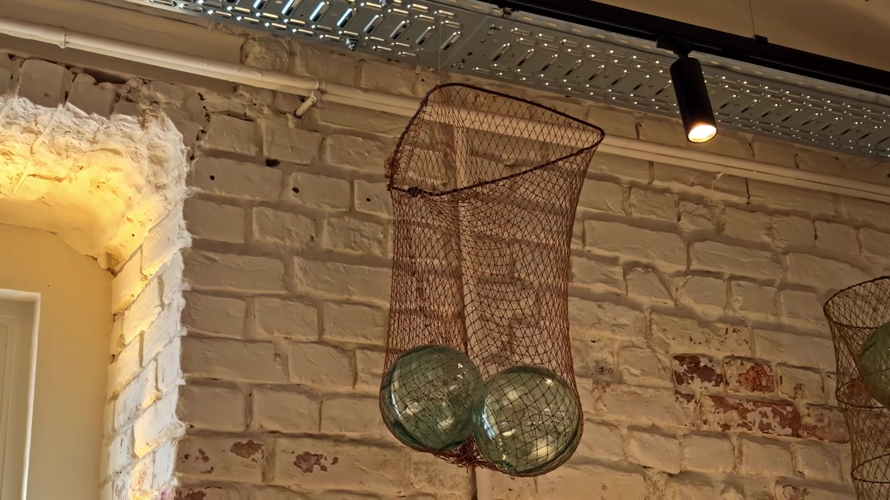 Decorative industrial-style hanging light fixtures green glass spheres housed in wire mesh nets
