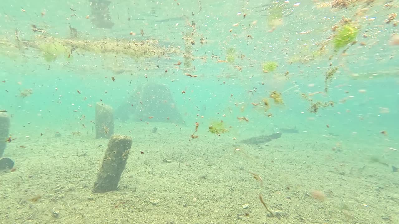 Underwater View of a Shallow Body of Water with Debris and Structures
