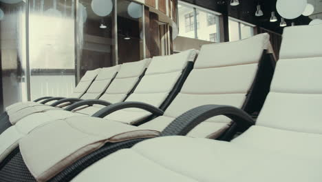 pool beds near pool in swim spa. deck chairs standing in luxury spa background.