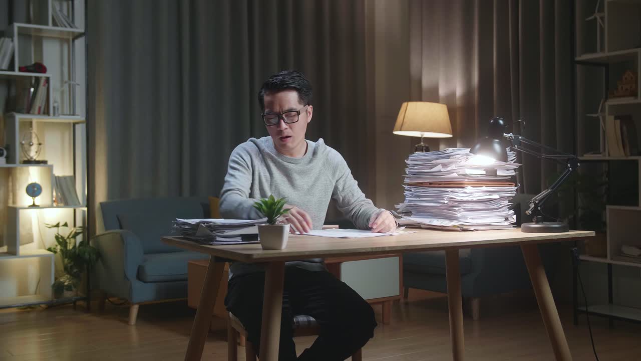 hombre estresado trabajando hasta tarde en la noche