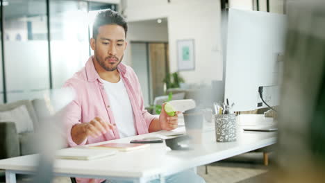 Hombre-Asiático,-Trabajando-Y-Comiendo-Manzana-En-La-Oficina