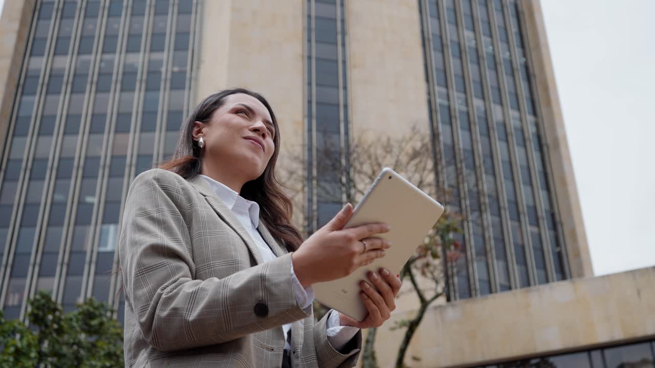 Primer plano en ángulo bajo de una mujer usando una tablet en la ciudad de Bogotá.