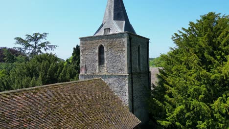 Close-up-reveal-of-a-village-church-tower-with-bright-blue-skies-in-the-village-of-Littlebourne,-Kent,-England