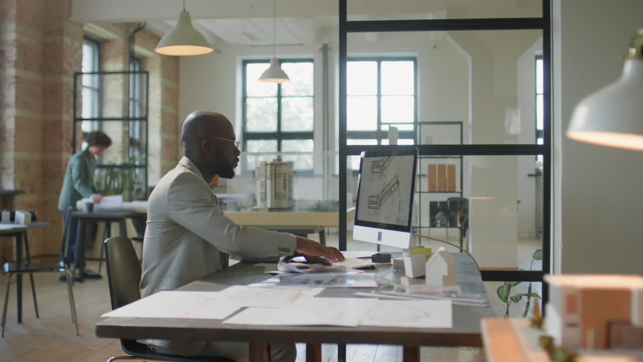Professional architect working on design plans in a modern office studio