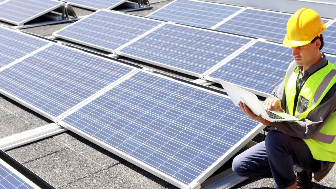 Male worker using laptop at solar station 4k