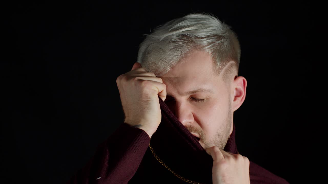 트렌디한 옷을 입은 파란 눈을 가진 세련된 남자가 카메라를 바라보고 행복, 재미, 즐거움을 느니다.