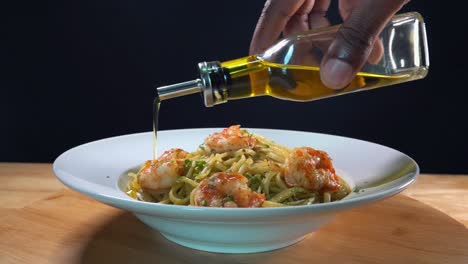 Toma-Deslizante-De-Aceite-De-Oliva-Virgen-Extra-Que-Se-Rocía-Sobre-Un-Plato-De-Camarones-Y-Pasta