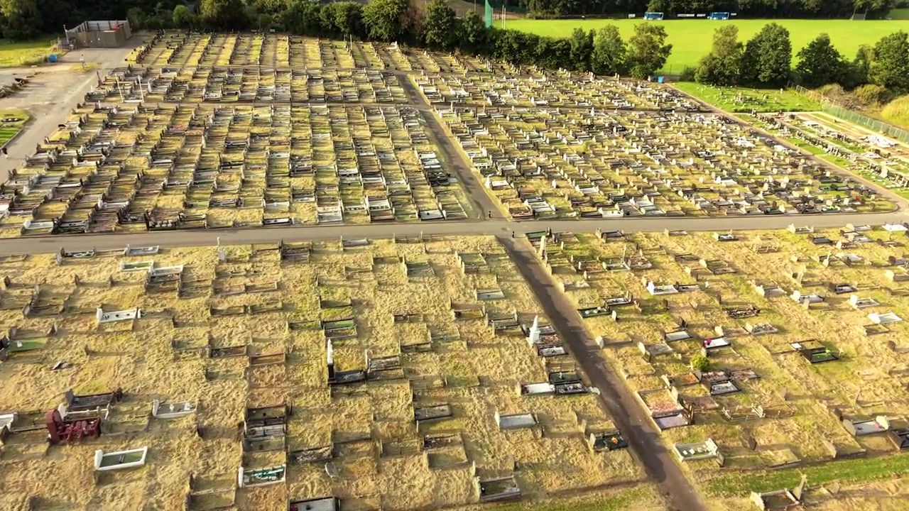 Dalende 4K 60FPS luchtopname van Milltown Cemetery en het Ierse Republikeinse Perceel aan de Falls Road in Belfast, Noord-Ierland, VK. Geproduceerd met uitzendklare Rec709-kleur.