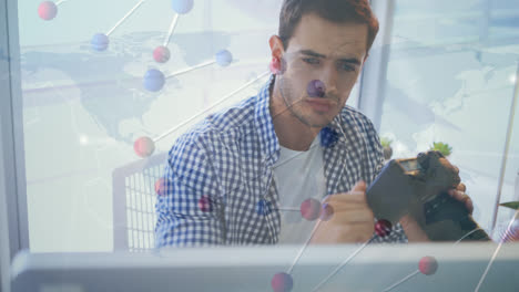 Dna-structure-spinning-over-caucasian-male-photographer-holding-a-digital-camera-at-office