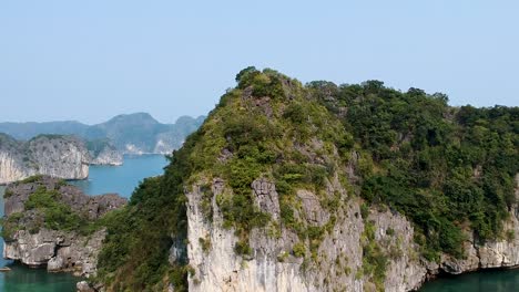 Aerial-drone-shot-over-Ha-Long-Bay,-blue-sea-and-limestone-islands-of-Lan-ha-bay