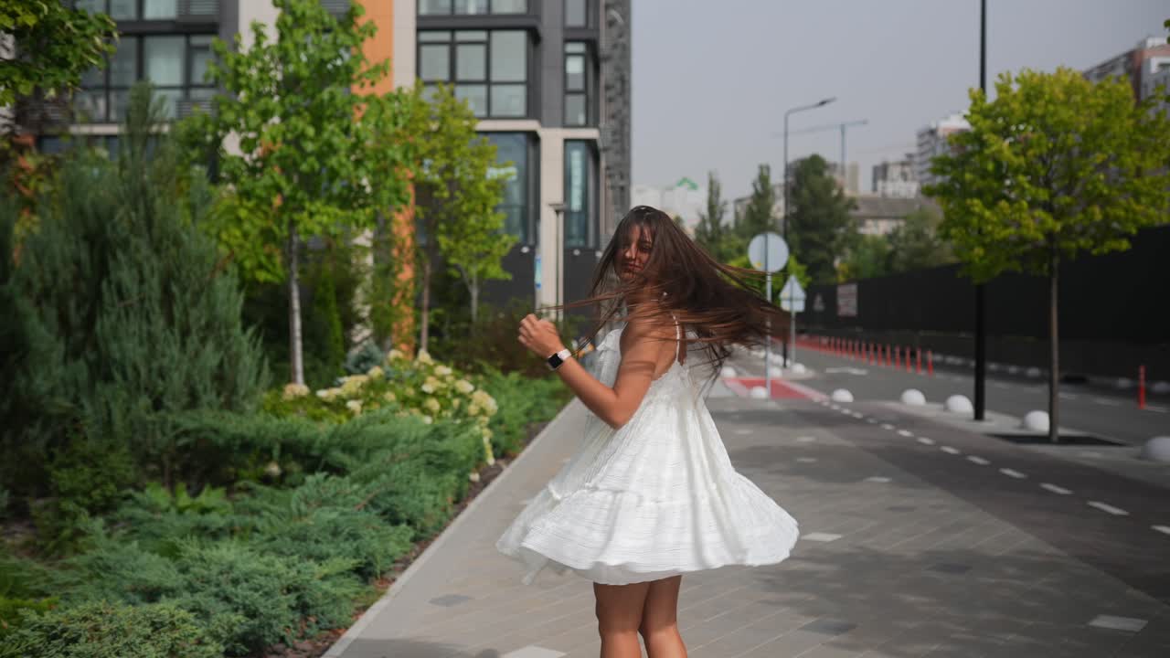 mujer con un vestido blanco y sombrero de paja caminando al aire libre