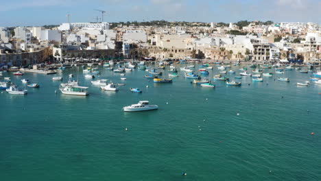 colorful boats in the harbor of mediterranean fishing village marsaxlokk, malta - aerial drone shot