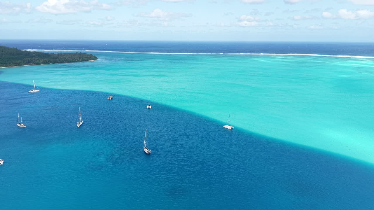 French Polynesia, Drone Shot of Sailboats in Magnificent Lagoon, Coral Reef Barrier Around Island