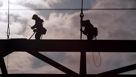 construction workers silhouetted against the sky