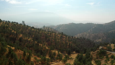 neblina humeante llena el cielo sobre las montañas rojas en un año de incendios forestales récord - vista aérea