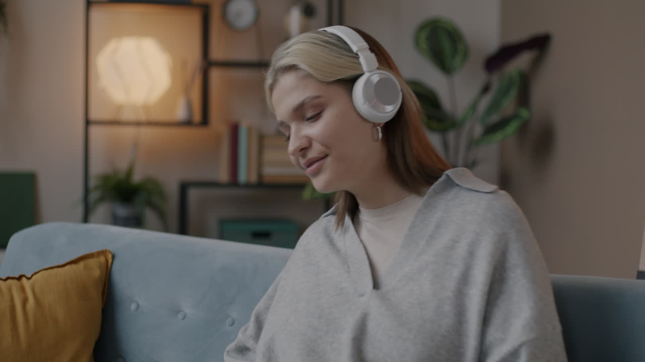 소파 에서 음악 을 듣고 있는 여자