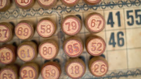 cinematic close-up smooth pan left, shot from above of a bingo wooden barrels, woody figures, old numbers background, vintage board game, lucky number, professional lighting, slow motion 120 fps