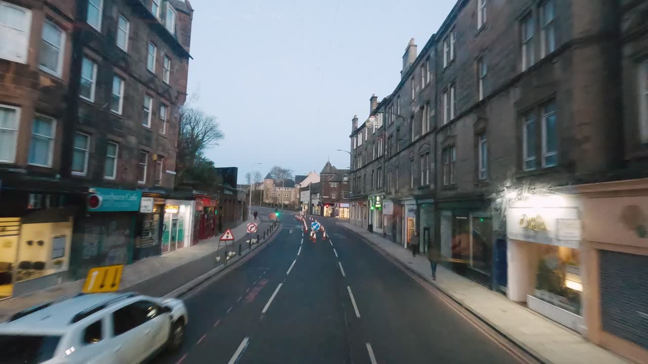 Magical sunset ride through the charming streets of Edinburgh aboard a double-decker bus, immersing in the city's vibrant atmosphere