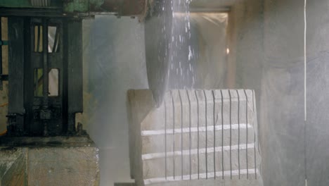 a professional machine is cutting a large stone in the building of a stone processing plant. stone processing technology using water