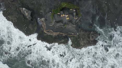 el templo de tanah lot se encuentra en un afloramiento de roca en la escarpada costa del océano de bali
