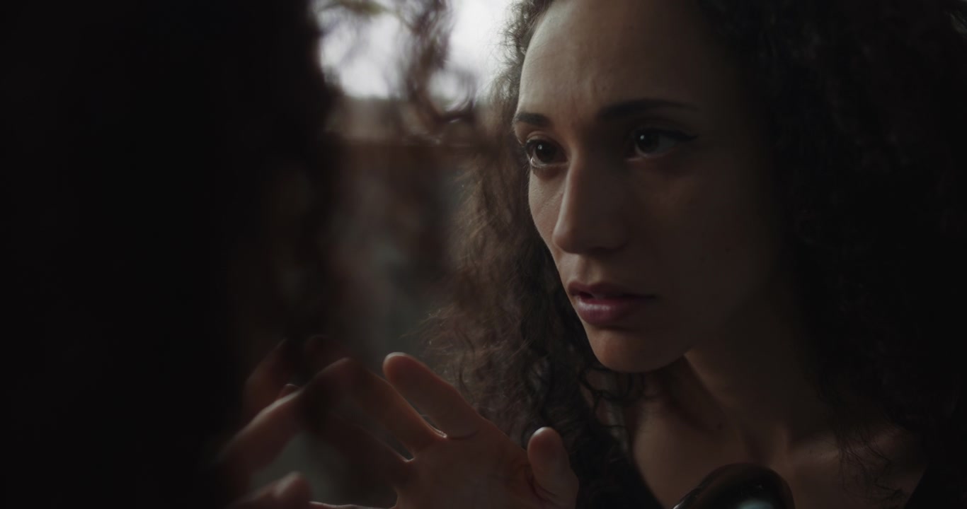 Una giovane donna triste che tocca lo specchio