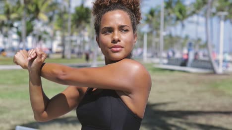 woman stretching arm in park