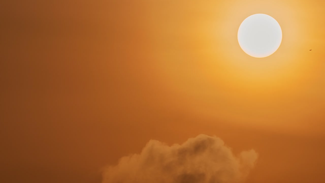 Smuk gylden solopgangs-timelapse med glødende sol over mørke skyer.