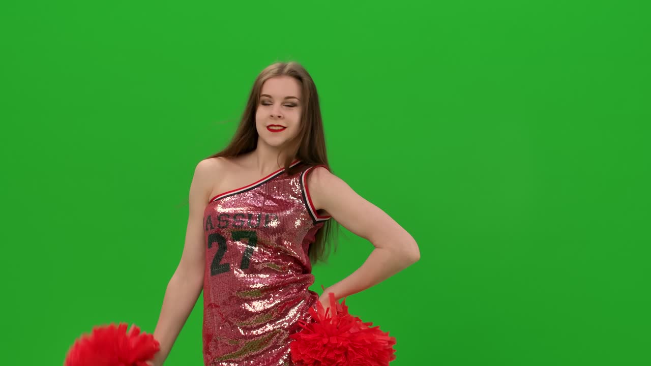 la animadora de pelo largo realiza elementos de pop-pong mientras entrena en el estudio en una pantalla verde. el concepto de juegos de equipo, deportes profesionales. de cerca. cámara lenta