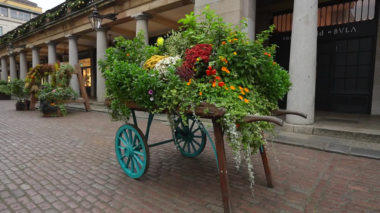 Colorful flower cart with green plants in Covent Garden Market in London on a cloudy day