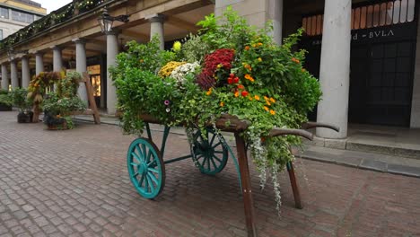 colorful flower cart with green plants in covent garden market in london on a cloudy day