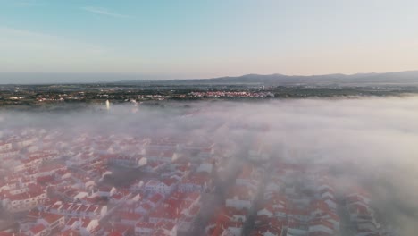 panoramic aerial view of red roofscape enveloping foggy clouds in portugal