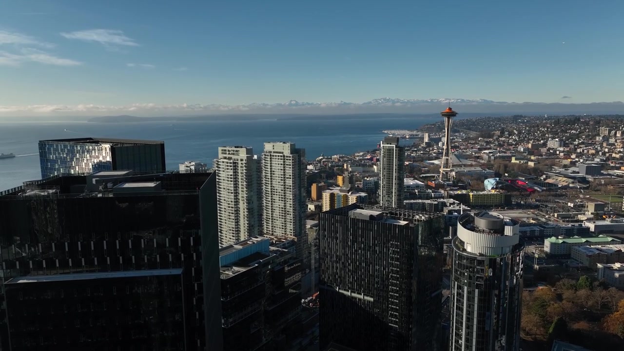 Ripresa aerea in ascesa dalla Amazon Day One Tower che rivela il paesaggio urbano con lo Space Needle di Seattle