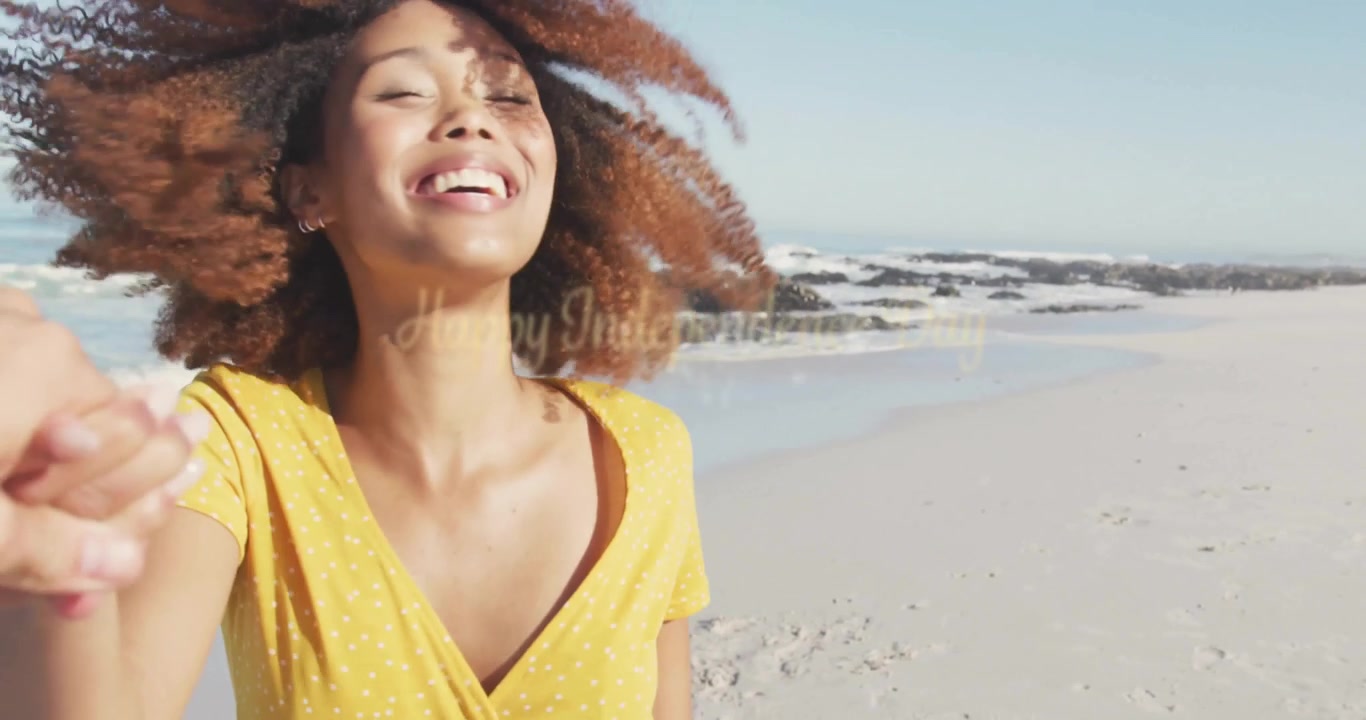 Woman holding partner hand pulling camera and spinning on beach with Independence Day text overlay