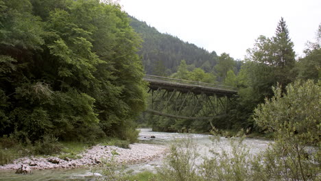 historic railway bridge over a crystal-clear alpine river, mountain landscape