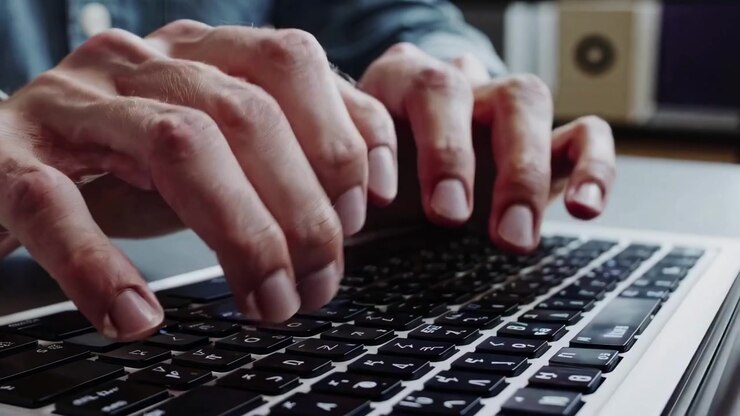 Close-up of Person Typing on Laptop Keyboard