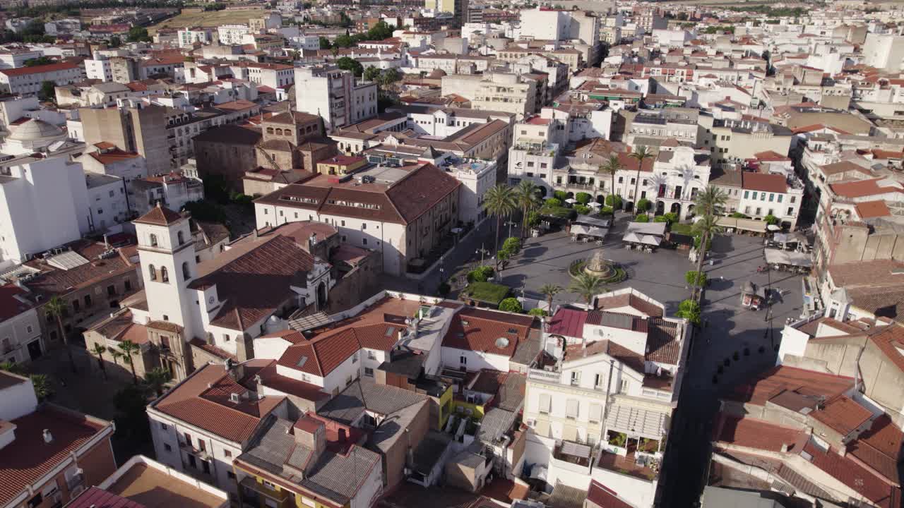 Aerial view orbiting Plaza de Espa&ntilde;a with its central marble fountain in the bustling Merida town square, Badajoz