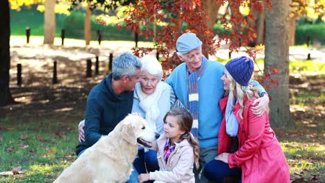 family sitting in the park with their dog