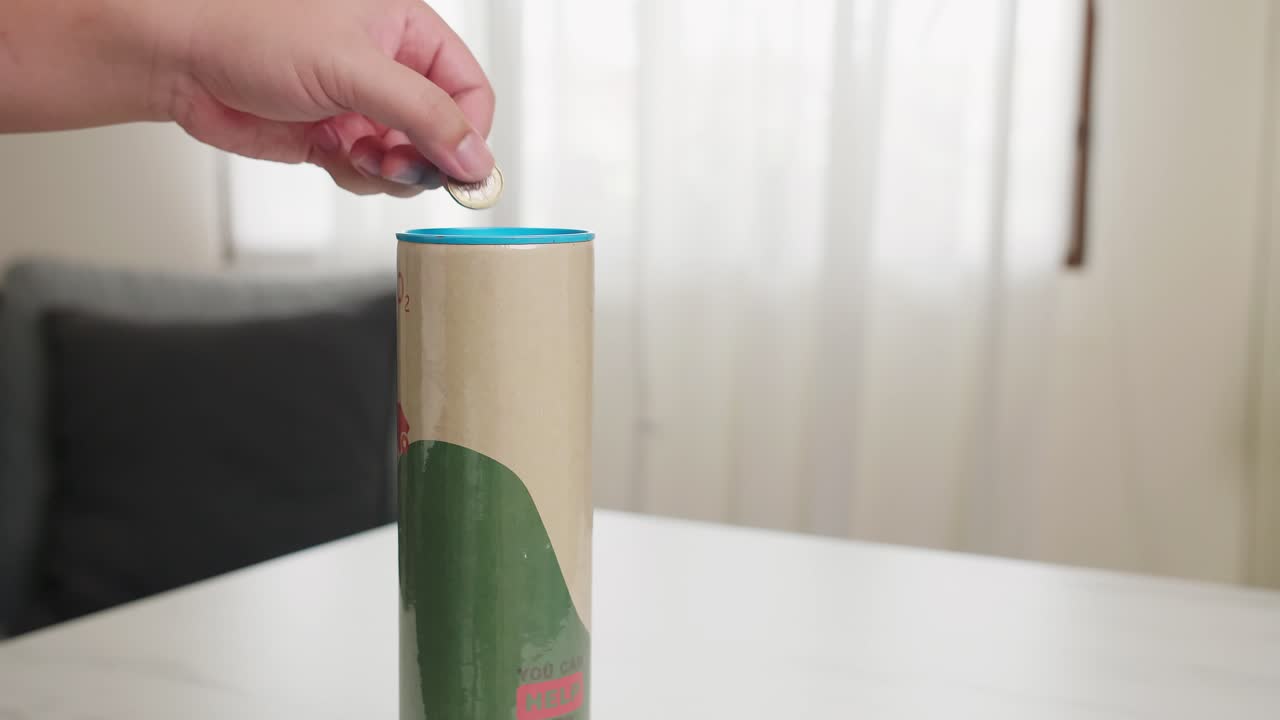 la mano del hombre está poniendo una moneda en la caja ahorrando dinero para un banco de caja de estilo de vida