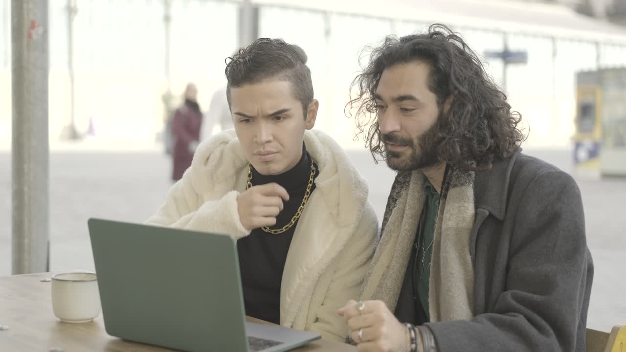 Two men looking at a laptop
