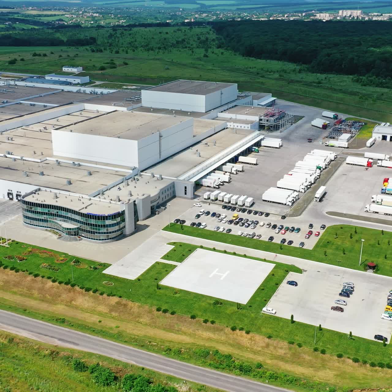 Contemporary industrial complex. Huge territory of production plant on nature background. View from the air. Motion camera top down.
