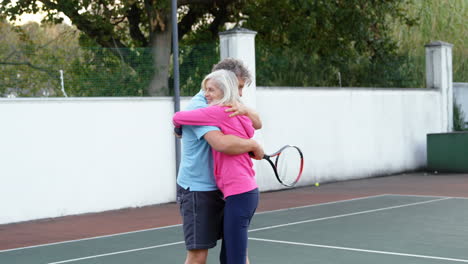 Pareja-Mayor-Abrazándose-En-La-Cancha-De-Tenis-4k