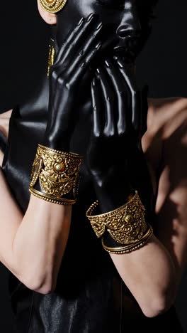 artistic portrait with black body paint and gold bracelets