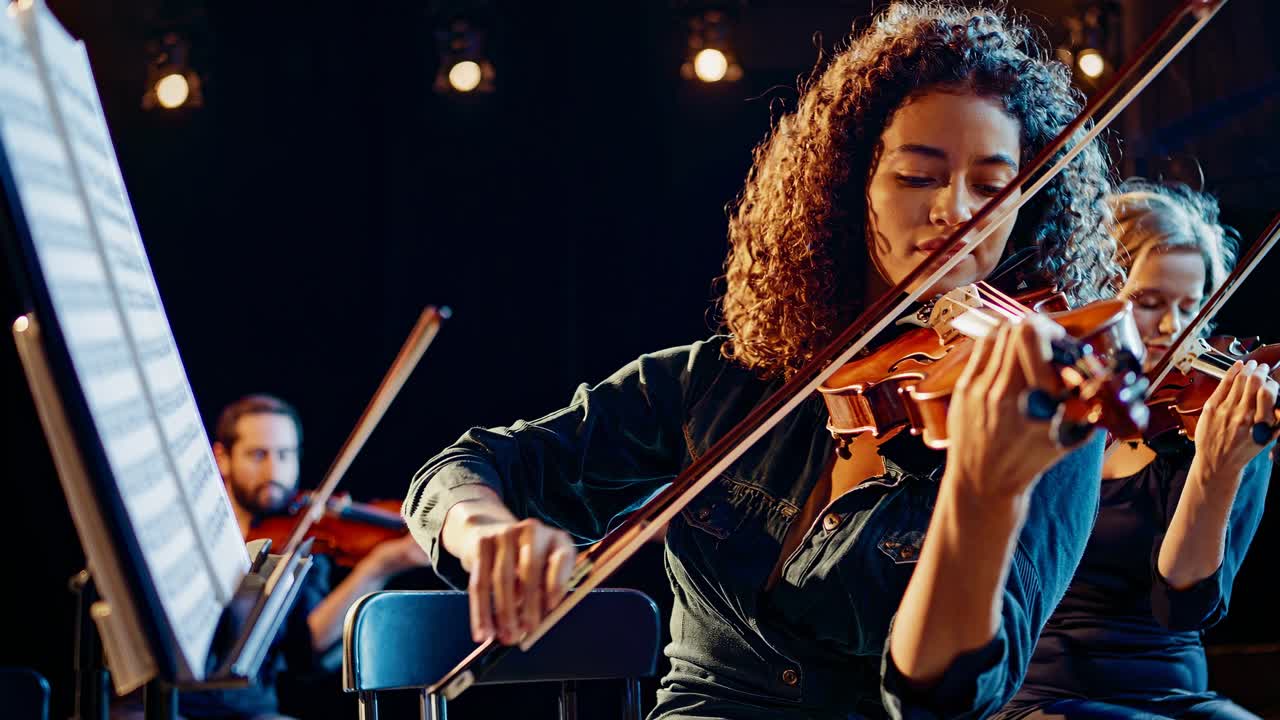 Close-up, side-angle video of a young violinist playing passionately, highlighting the focus