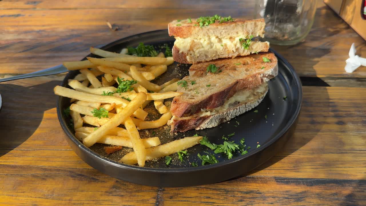 A chicken and mayonnaise sandwich with french fries on a plate in a diner.