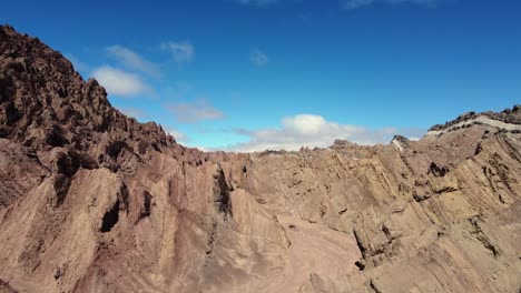 aerial rises over rugged red rock canyon, canon del indio in argentina