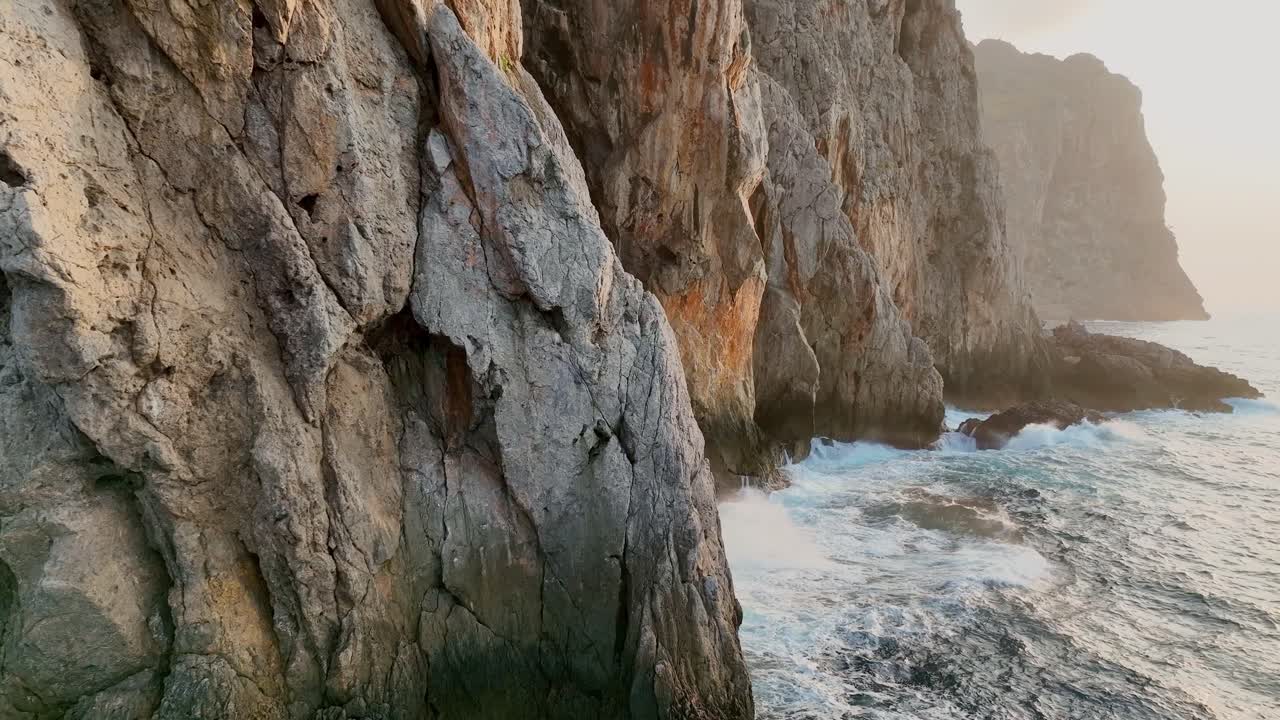 Revealing the sun from behind a mountain wall, with drone.