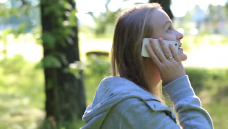 Woman-chatting-on-her-mobile-phone-outdoors