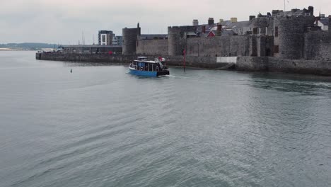 following sightseeing boat sailing caernarfon castle welsh harbour town river aerial view